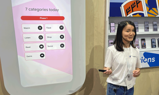 Ting Mui Li, a Google product manager, in front of a screens that shows the first seven Google Play Collections categories.